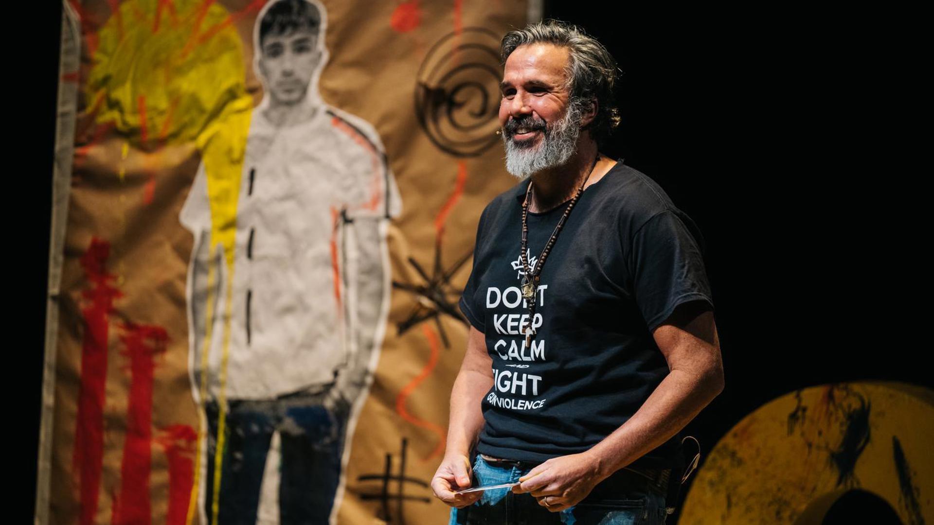 Manuel Oliver in GUAC performs, an artistic portrait of his son can be seen in the background.