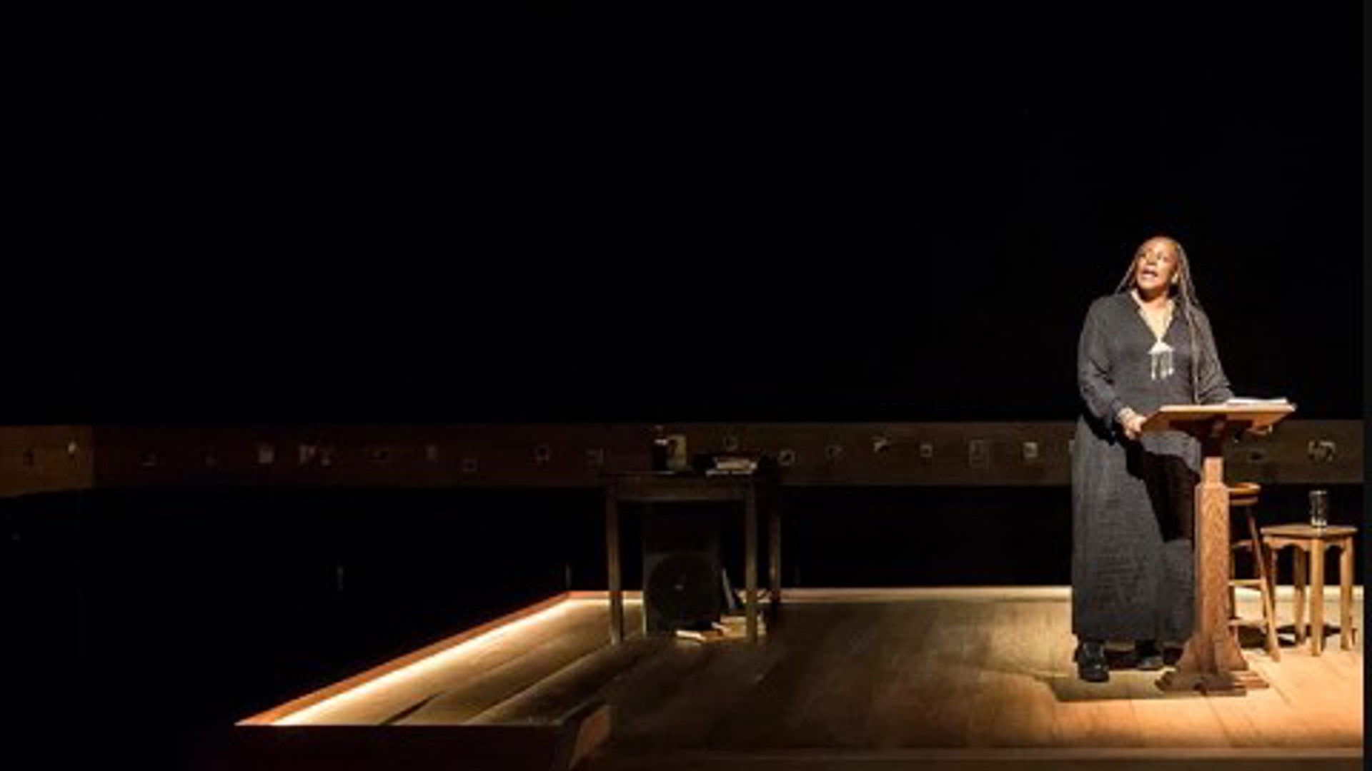 Dael Orlandersmith standing on stage at a podium doing a monologue in Los Angeles