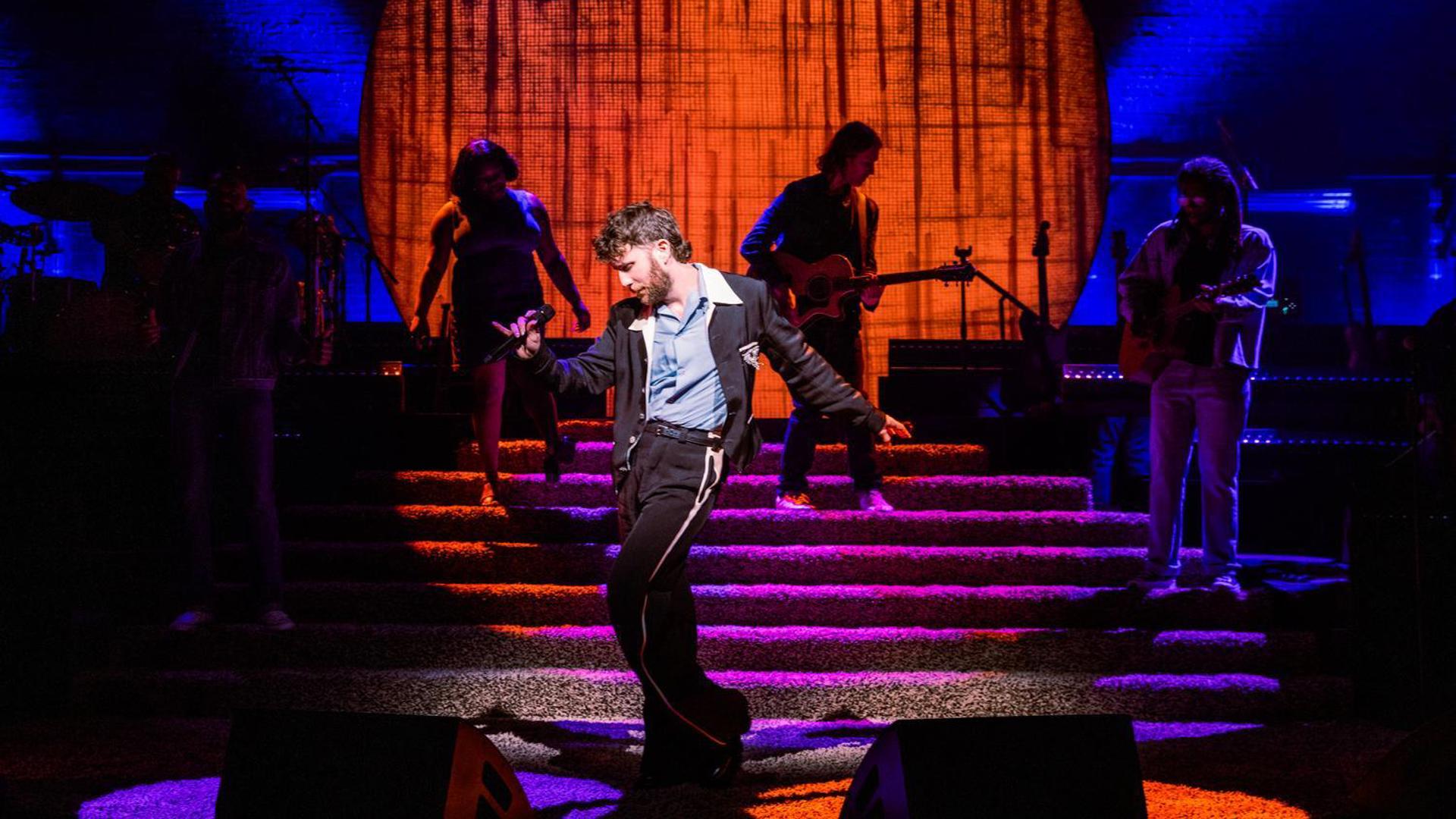 Ben Platt poses while his band performs behind him. 