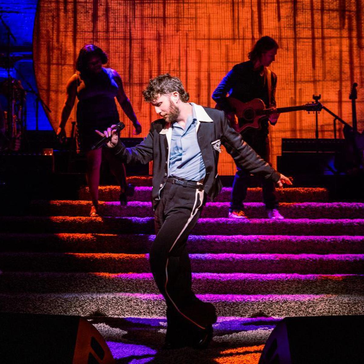 Ben Platt poses while his band performs behind him. 
