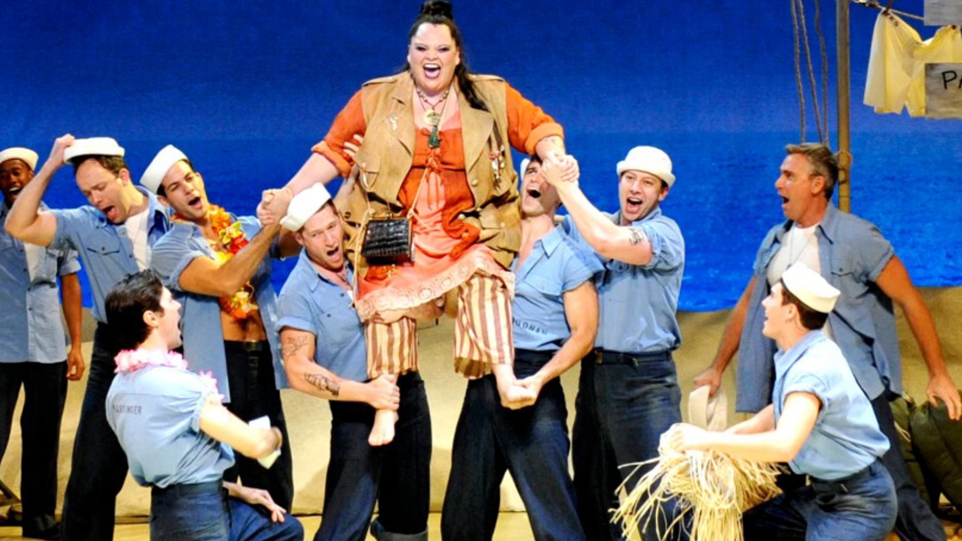 the cast of South Pacific in costume on stage in a musical number