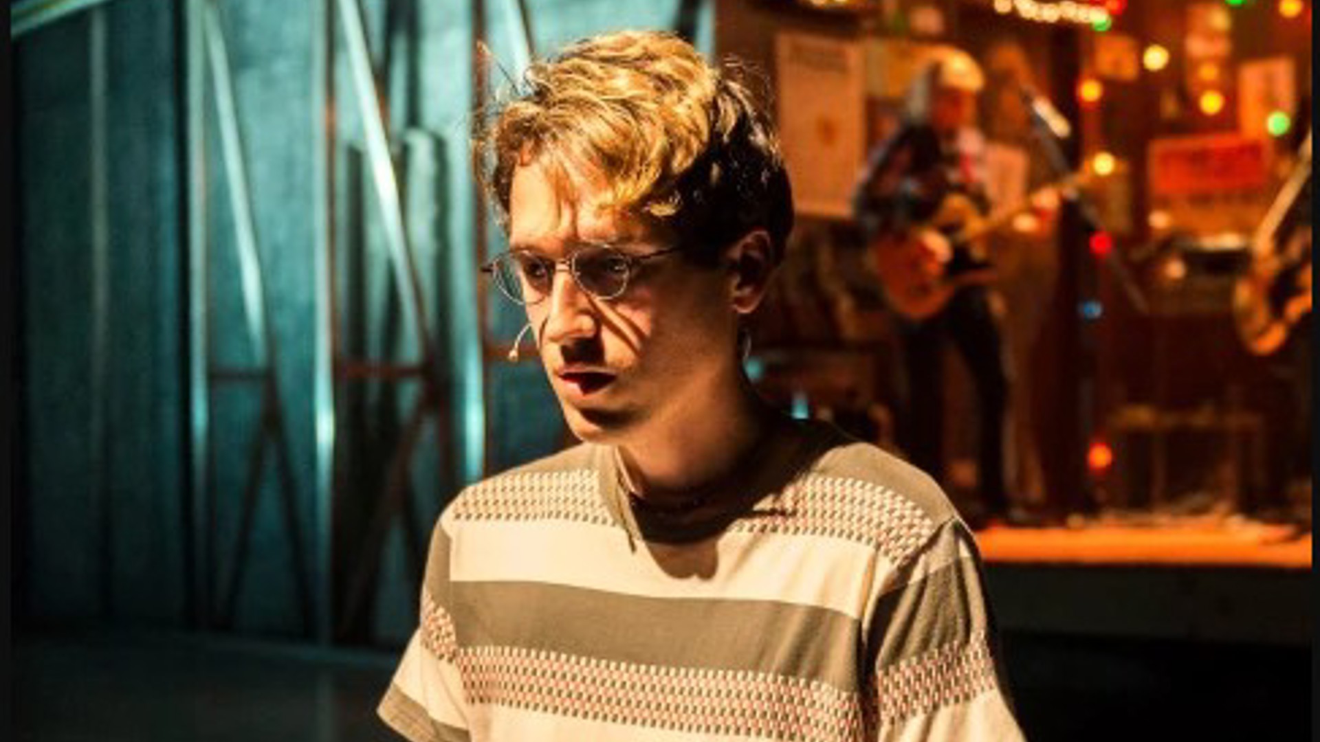 Ryder Bach in front of a Nebraska music bar scene in the play Girlfriend