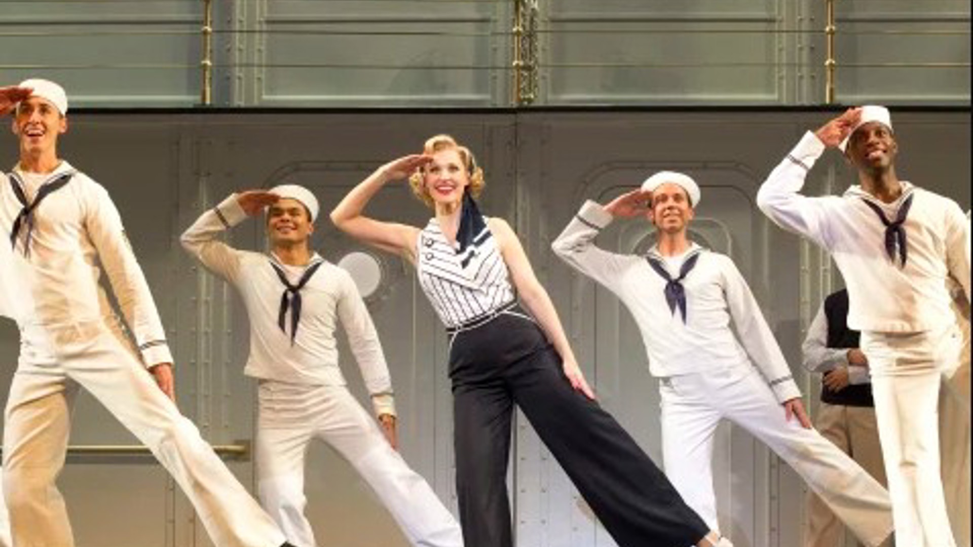 a female and 4 male sailors saluting and dancing 