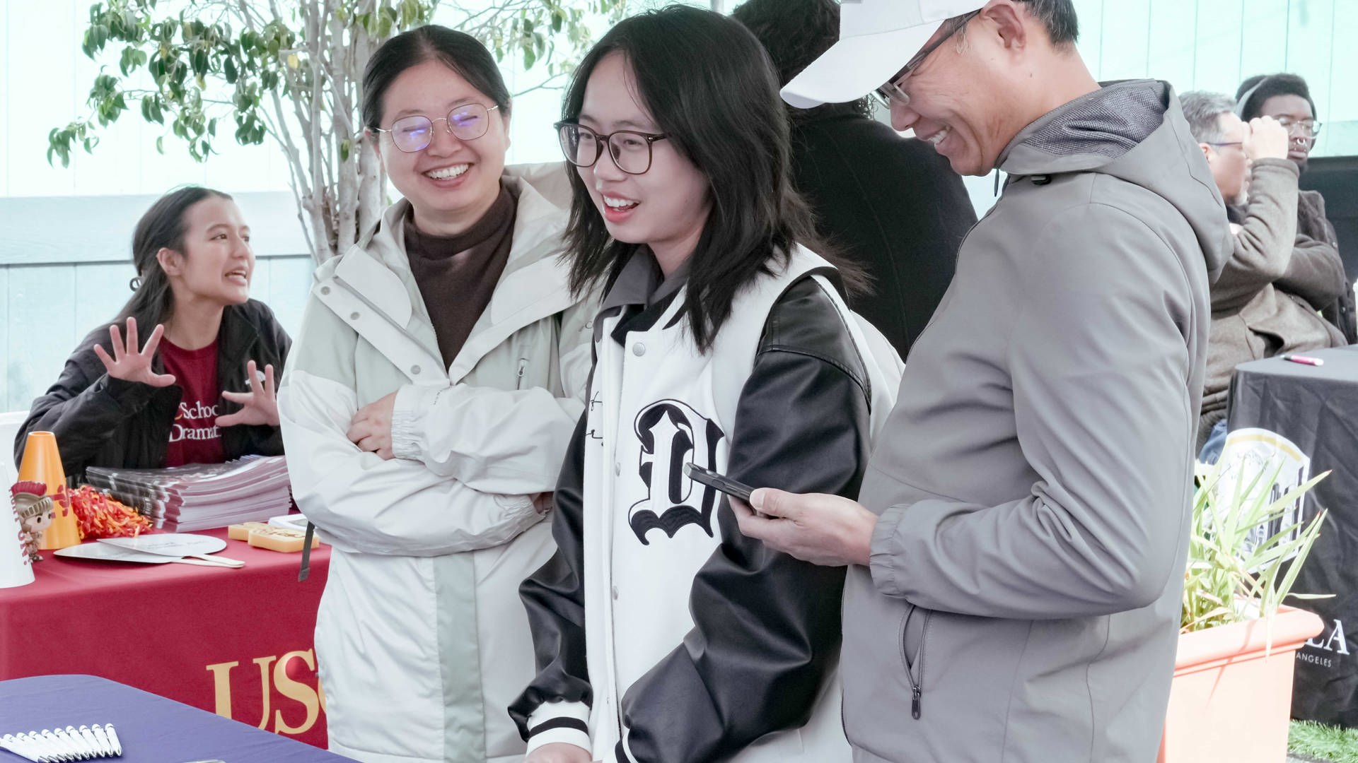 Three people looking at informational materials at a table. 