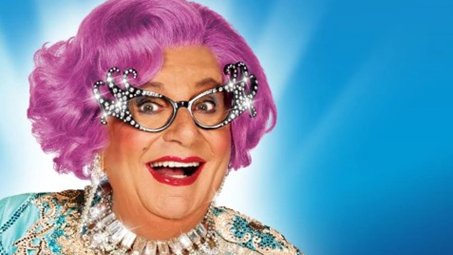 a beautiful headshot of Dame Edna smiling