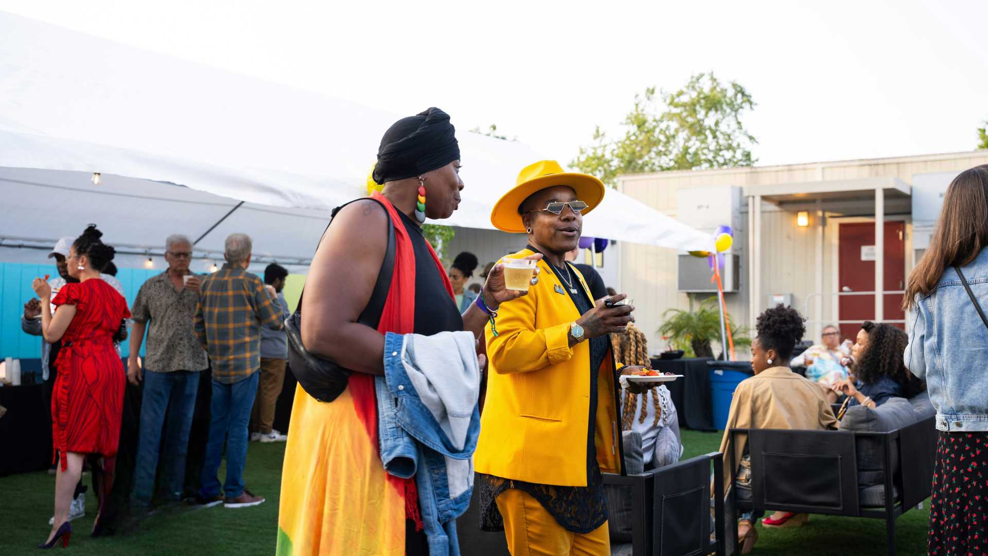 Two women socializing with drinks in their hands. 
